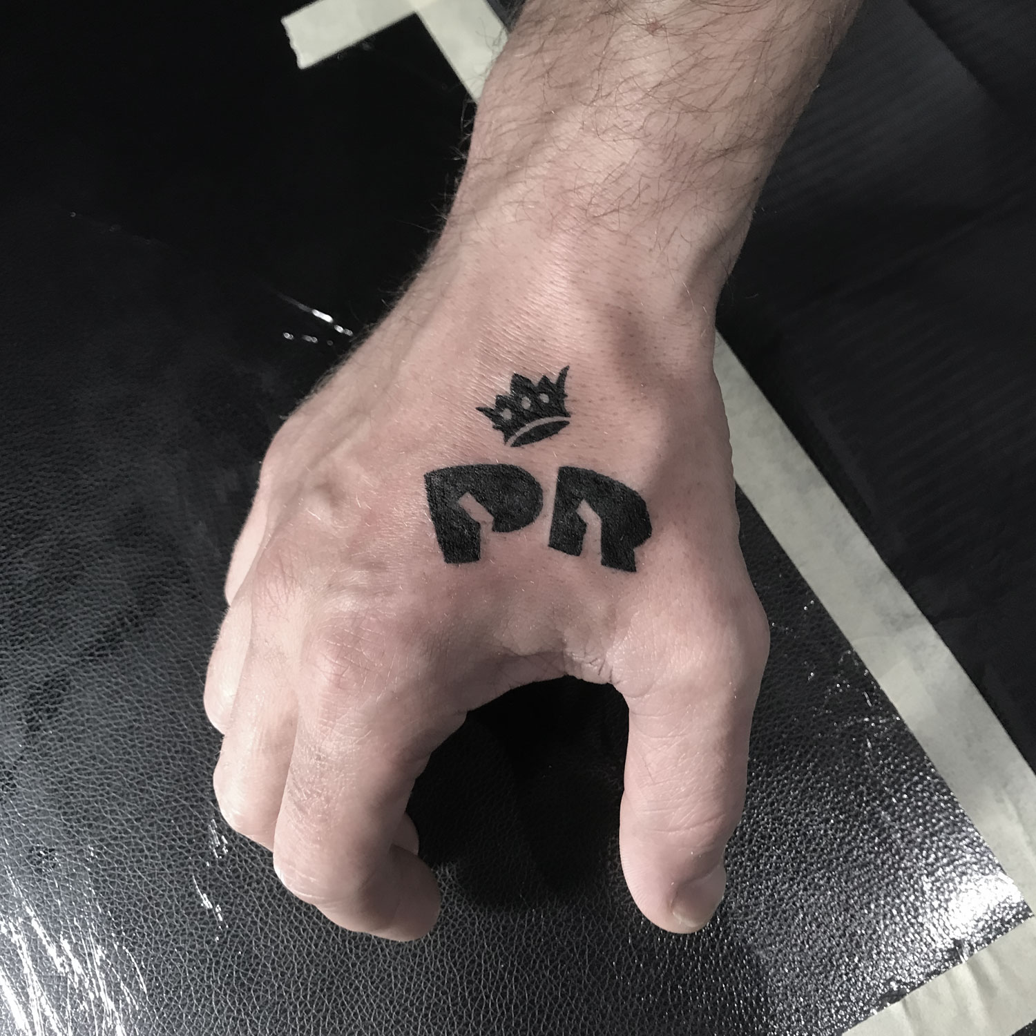 Tatuaje black work de un logo