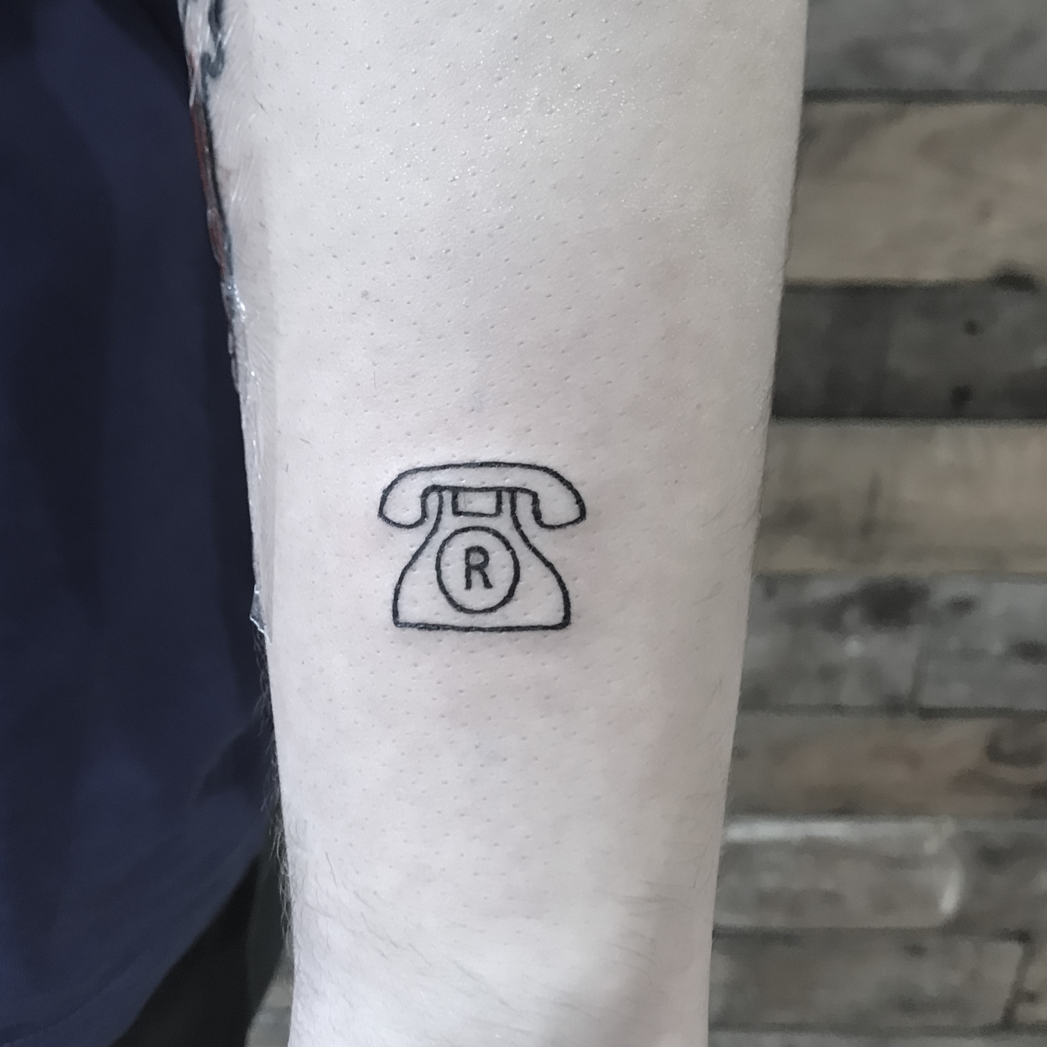 Tatuaje fine line de un teléfono