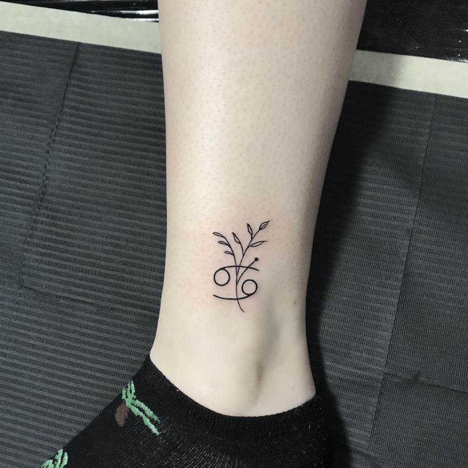 Tatuaje fine line de un signo del zodiaco con una rama