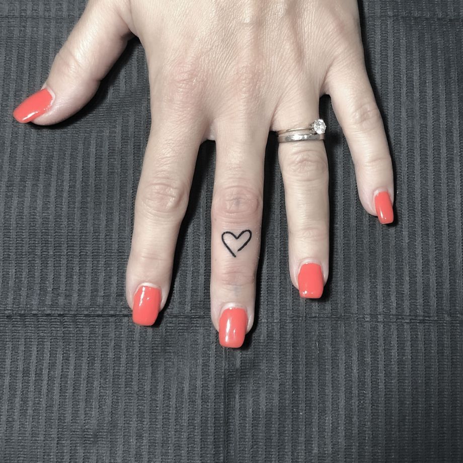 Tatuaje black work de la silueta de un corazón en un dedo