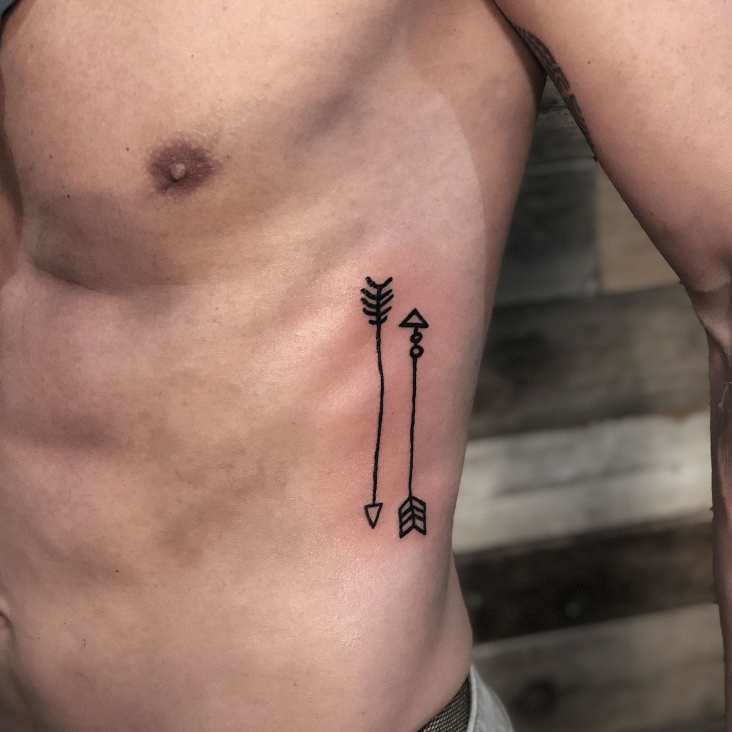 tatuaje blanco y negro de unas flechas