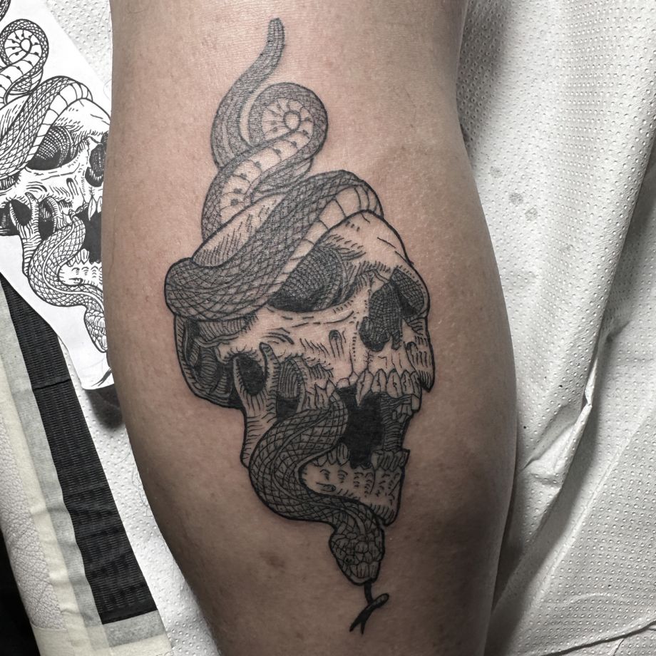 Tatuaje blackwork estilo engravers de una calavera y una serpiente