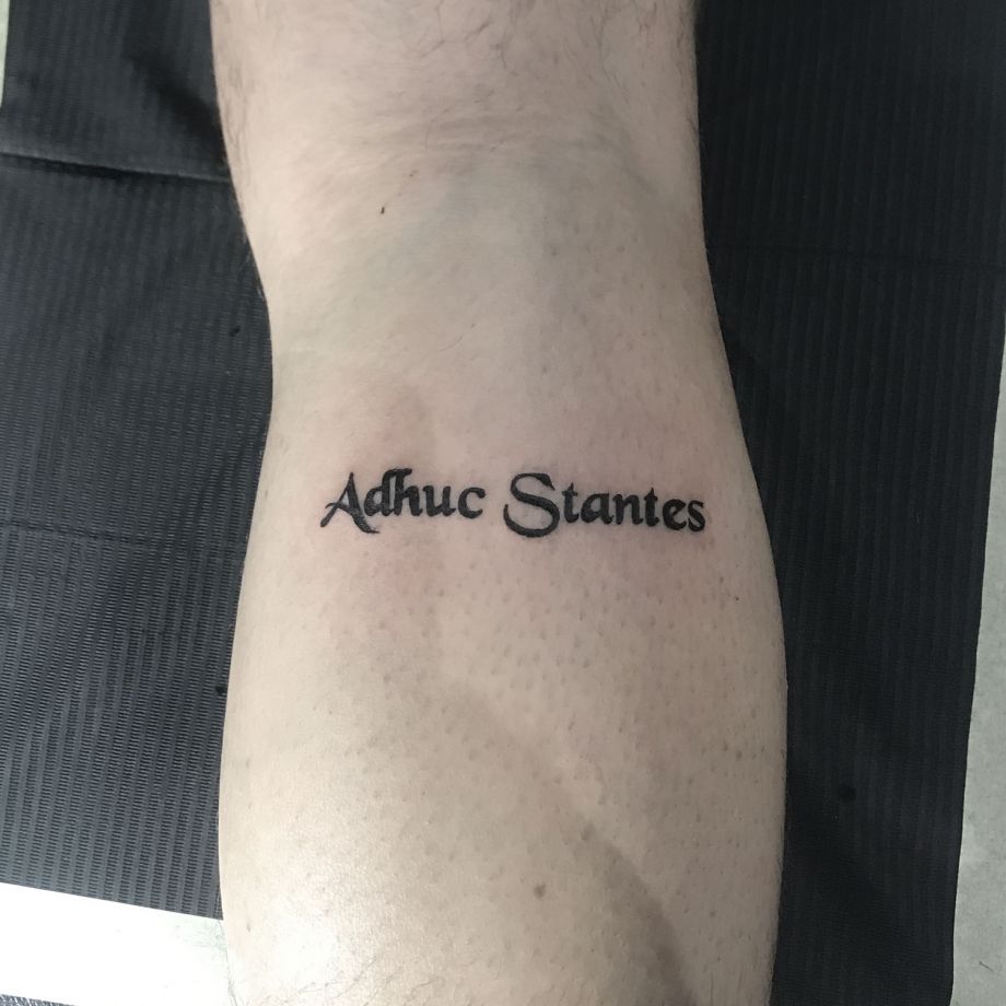 Tatuaje lettering "Adhuc Stantes"