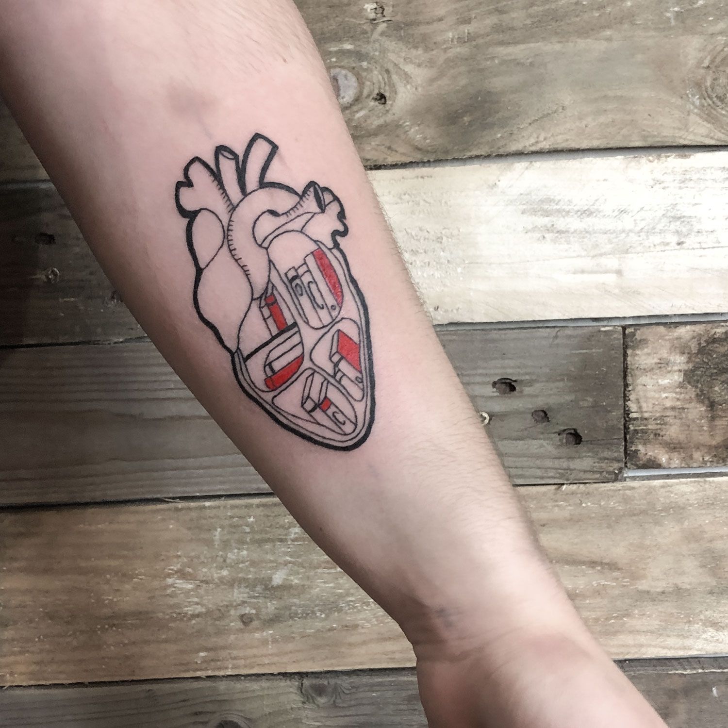 Tatuaje c y algo de color de un corazón con libros